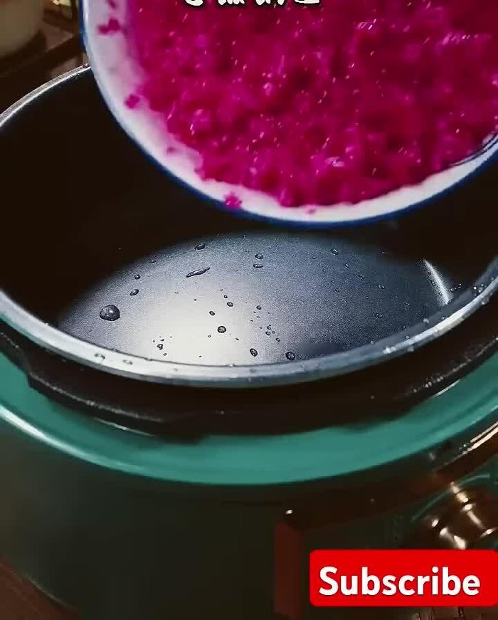 Crush dragon fruit and add it to the rice. Add normal water to the rice cooker. Close the lid and let the rice cook.