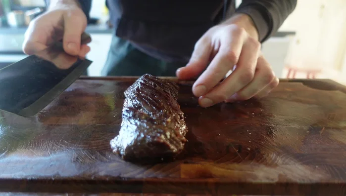 Assemble the Crying Tiger Steak: Slice the rested steak against the grain. Arrange on a plate with the lettuce, cucumber, and tomatoes. Serve with hot sauce (optional). (619.64)