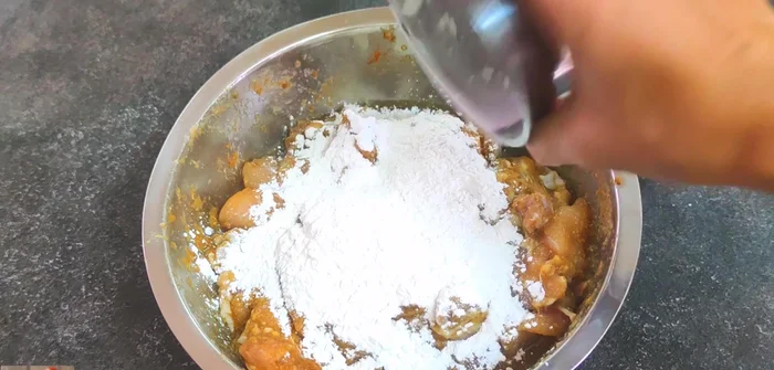 After marinating, add 3 tablespoons of rice flour, 1 teaspoon of all-purpose wheat flour, and 1/2 teaspoon of bicarbonate of soda to the chicken. Mix well.