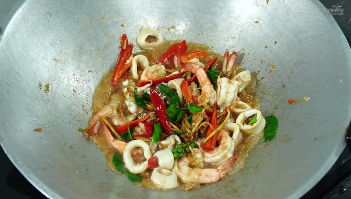 Continue stir-frying until shrimp and squid are cooked through.
