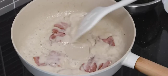 Add the cooked fettuccine to the sauce, mixing well to coat.