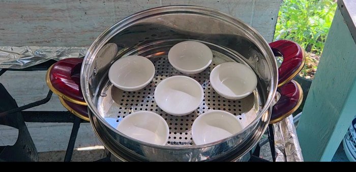 Spoon the cassava mixture into the prepared palm cups (or tray), leaving some space for the coconut milk topping.