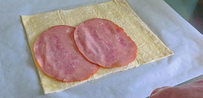 Layer sliced ham over the buttered pastry.