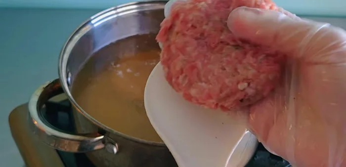 Add the pork sheets to the simmering water, gradually adding them in.