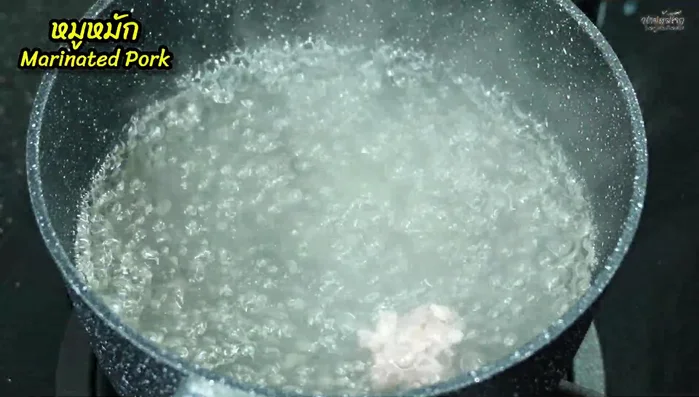 Form the marinated pork into small balls and add them to the boiling water.