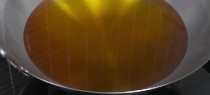 Carefully add the sea bass to the hot oil, skin-side down. Avoid splashing.