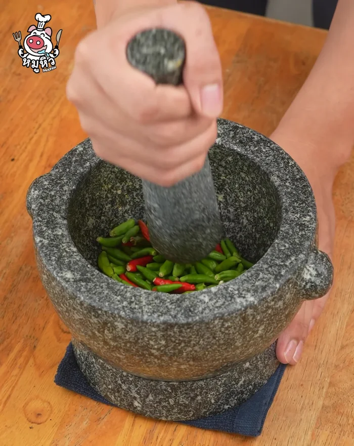 Pound chili peppers until fine.