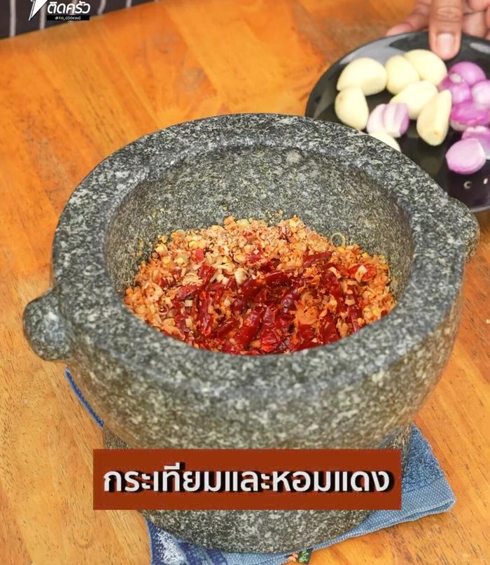 Add garlic, onions, and red chilies to the curry paste and pound until fine.