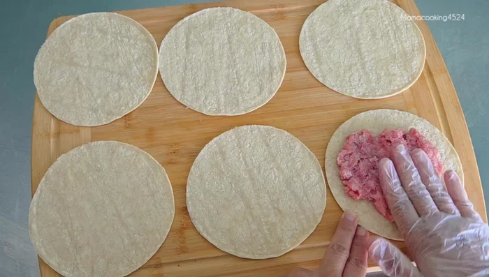 Spread ground pork thinly onto plates, pressing it into thin sheets.