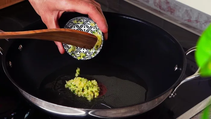 Preheat your wok oil and add the ginger, garlic, and chili.