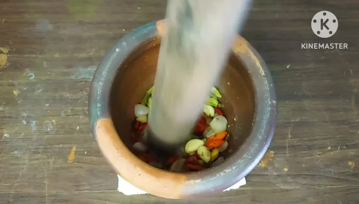 Pound the roasted shallots, garlic, and chili peppers until finely ground.