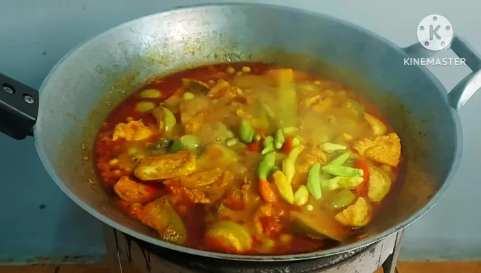 Add chili peppers, kaffir lime leaves, shredded galangal, and sliced long beans.