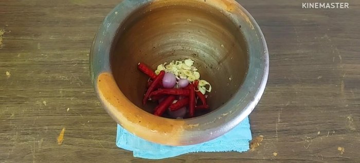 Prepare the curry paste: Chop red chili peppers, shallots, and lemongrass. Add a pinch of salt.