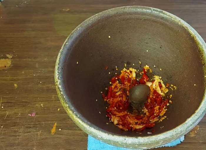 Add shrimp paste to the pounded chili and garlic mixture. Continue pounding until well combined.