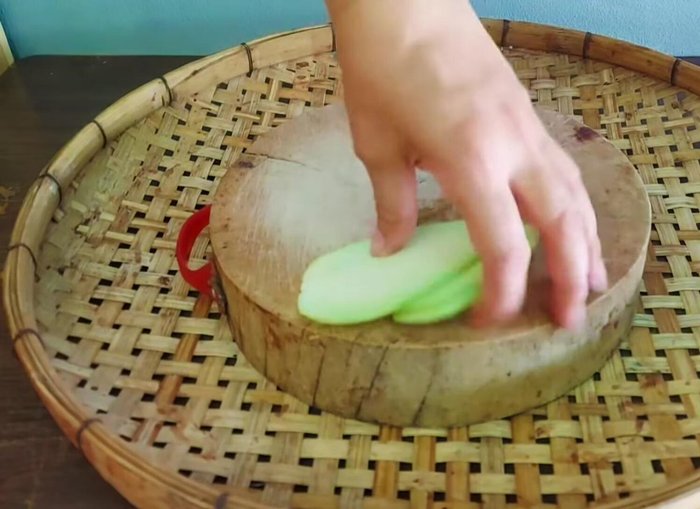 Slice the sour mango thinly and cut into small pieces.