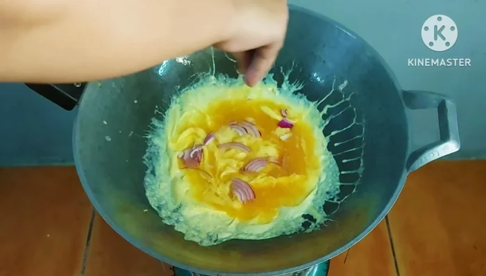 Add chopped shallots, tomatoes, chilies, and shrimp to the omelet.