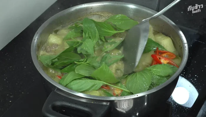 Add basil leaves at the end, ensuring the curry is boiling to preserve the basil's aroma and vibrant color.