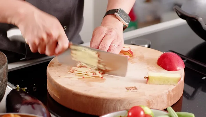 Prepare the vegetables: Slice the apple, onion, and cherry tomatoes. Snap the green beans in half.
