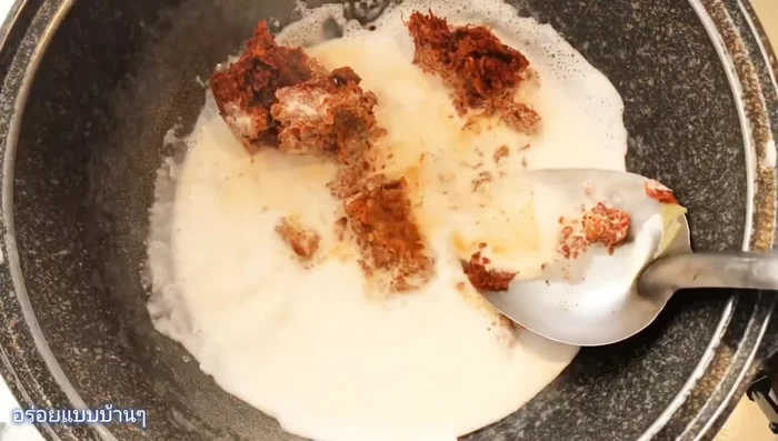 Add 200 grams of curry paste and stir until melted. Continue to cook on low heat until the coconut milk separates.