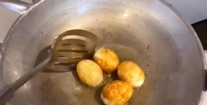 Fry the boiled and peeled eggs until golden brown.
