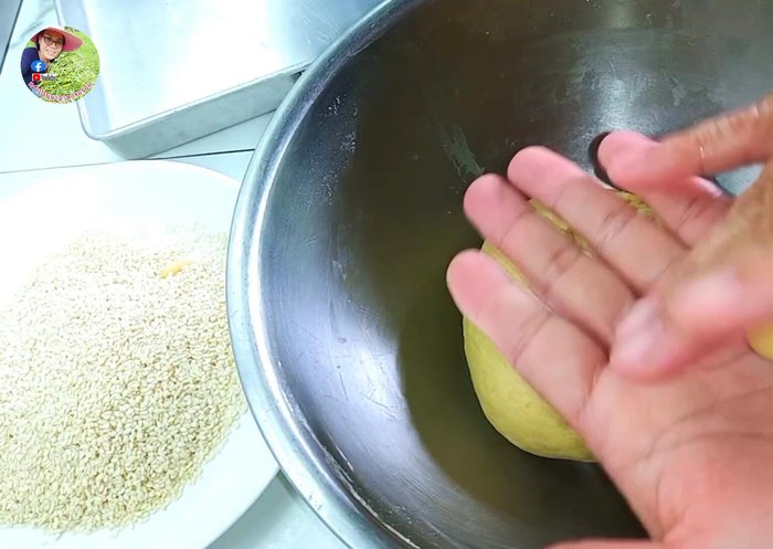Shape the dough using a teaspoon. Mix sesame seeds with the dough.
