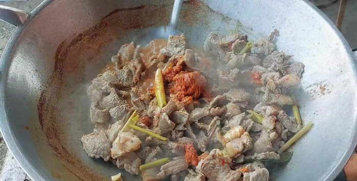 Add 100g of spicy curry paste and stir-fry until fragrant. Add water as needed to help stir-fry the paste.