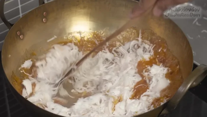 Add the steamed coconut to the caramelized sugar mixture and stir-fry until dry and the water is completely evaporated. This prevents a soggy filling.