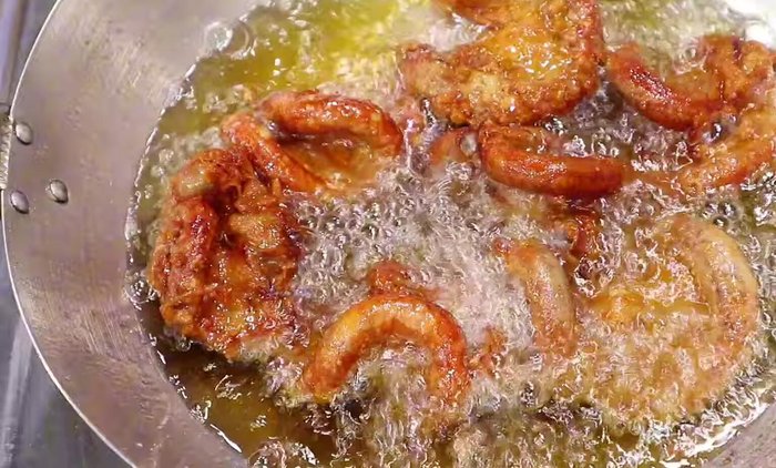 Add the seasoned chicken intestines and garlic to the hot oil. (This step is implied and not explicitly stated in the transcript.)