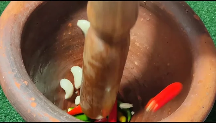 Pound chili and garlic together in a mortar. Adjust spiciness to your liking.