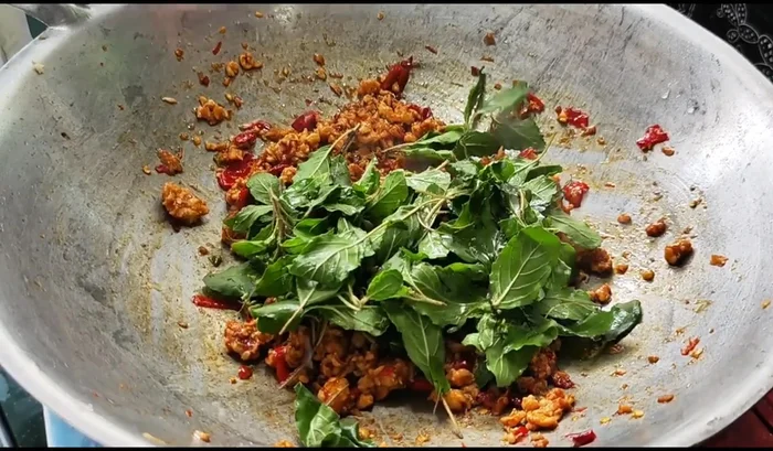 Add the basil leaves. Stir-fry until wilted but still vibrant green.