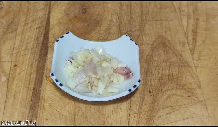Roughly pound one head of Thai garlic.