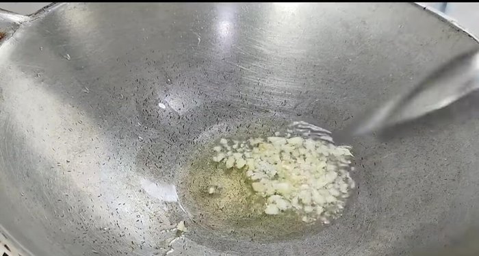 Heat a pan with oil. Add garlic and stir-fry.