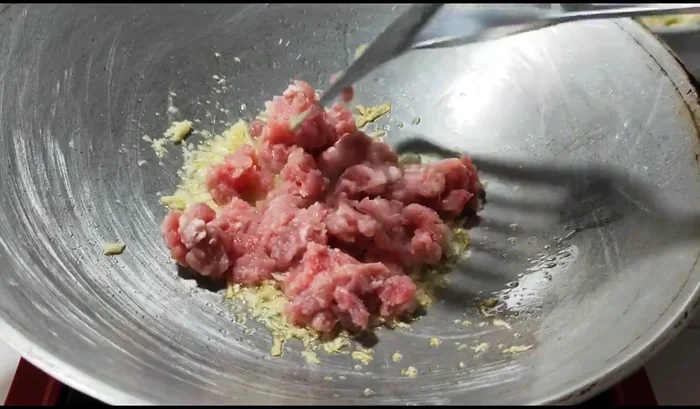 Add minced pork and stir-fry until cooked.