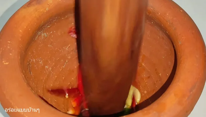 Pound the garlic and chilies until fine.