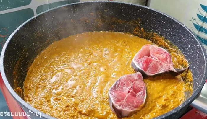 Gently add the catfish to the curry, ensuring not to stir it excessively.