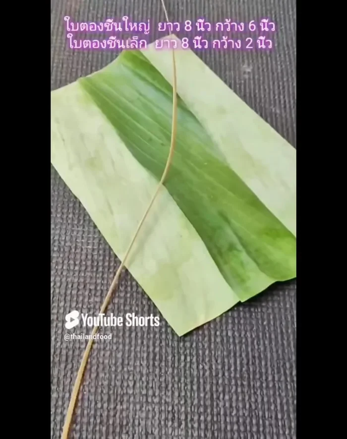 Make a banana leaf basket with a handle: Prepare two pieces of banana leaves (one large, one small). Soak a nail in water. Place the small banana leaf in the middle, cut to 2 inches, and fold the sides. Fold top and bottom, then left over right, right over left. Make small betel leaves into ears for the basket handles.