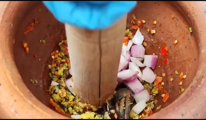Add the salted crabs and shallots. Continue pounding until everything is finely ground and well combined.