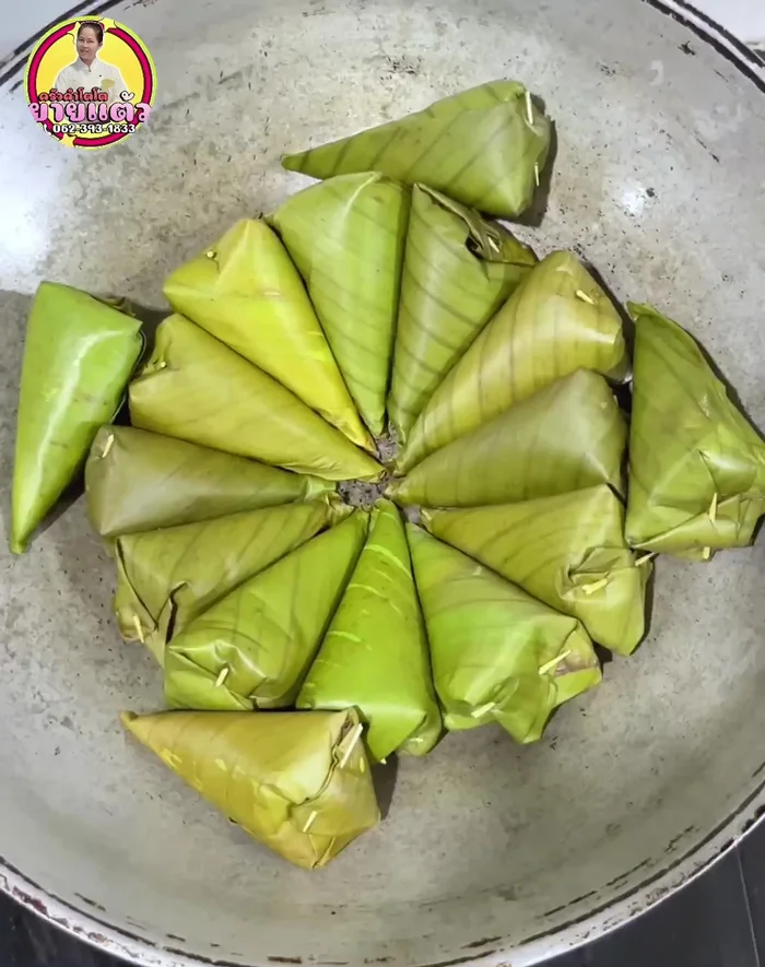 Grill the parcels: Place the wrapped sticky rice on a pan over low heat. Grill for 4-5 minutes per side, ensuring the sticky rice touches the pan for even grilling. Be careful not to burn the banana leaves.