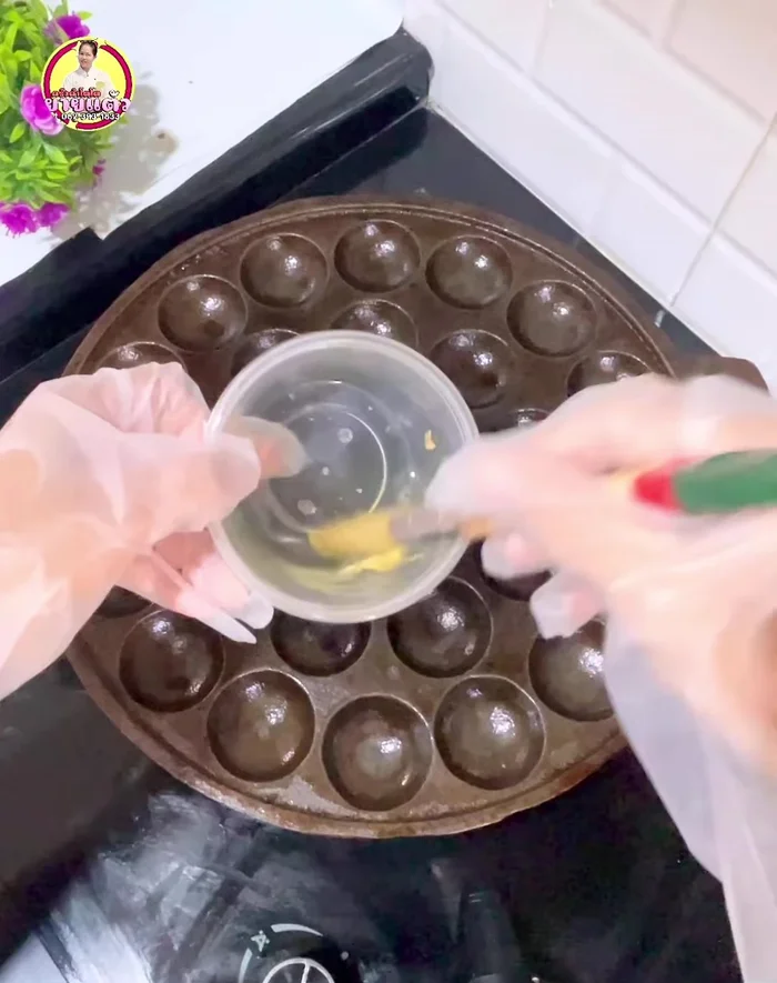 Oil Khanom Krok molds. Cook the batter in the molds over low heat. Stir the batter before scooping. Cook until golden brown.