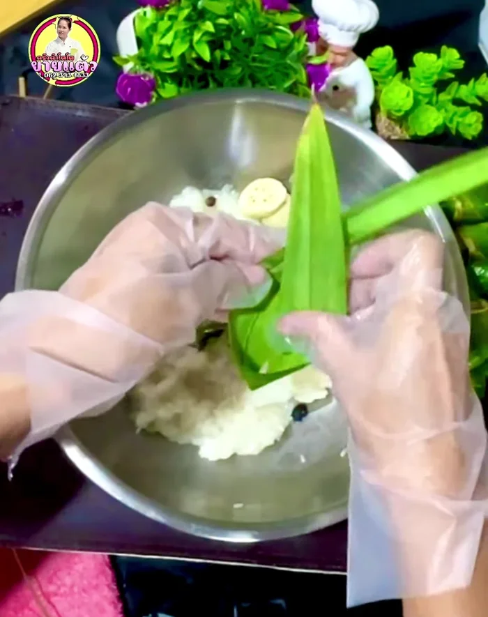 Assemble the rice porridge: Layer pandan leaf, black beans, sticky rice, more beans, bananas, and another layer of sticky rice. Fold the pandan leaf to create a bundle.
