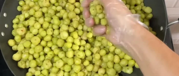 In a pan, combine the star gooseberries, 1 kg unrefined sugar, 2 teaspoons of salt, and 250 ml of water. Mix well.
