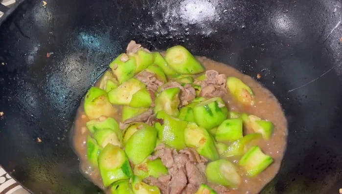 After 2 minutes, uncover the pan, increase heat, add the cooked eggs, and stir-fry quickly until everything is well mixed.