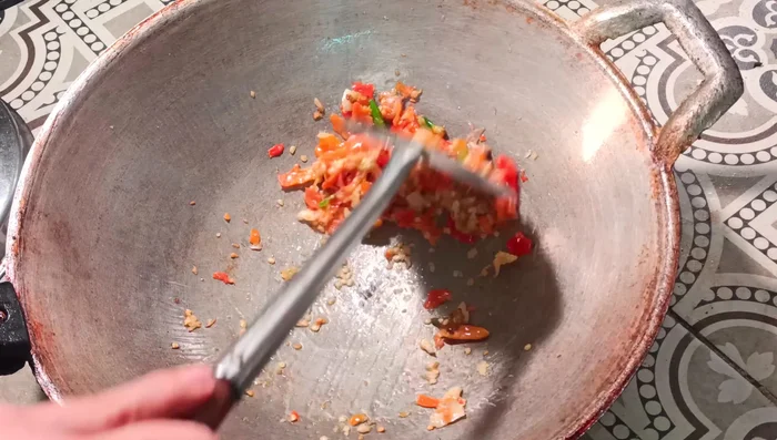 Heat a wok or frying pan over medium heat. Add the pounded chili and garlic and stir-fry briefly.
