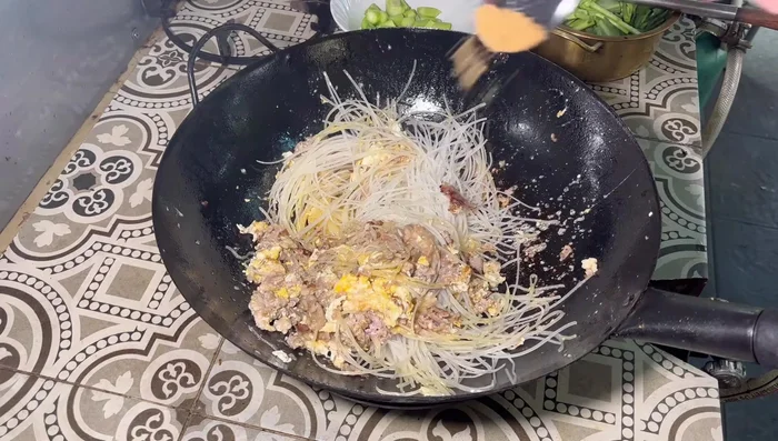 Stir-fry noodles, mixing with pork and eggs. Season with sugar, banana peel seasoning powder, oyster sauce, and a little bit of other seasonings (be careful not to over-season).