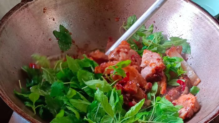 Prepare ingredients: Chop garlic, chili, and holy basil. Prepare crispy pork belly.