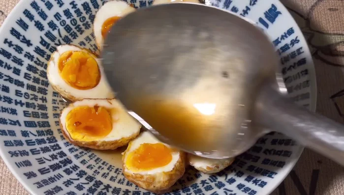 Cut the fried eggs in half and pour the tamarind sauce over them.