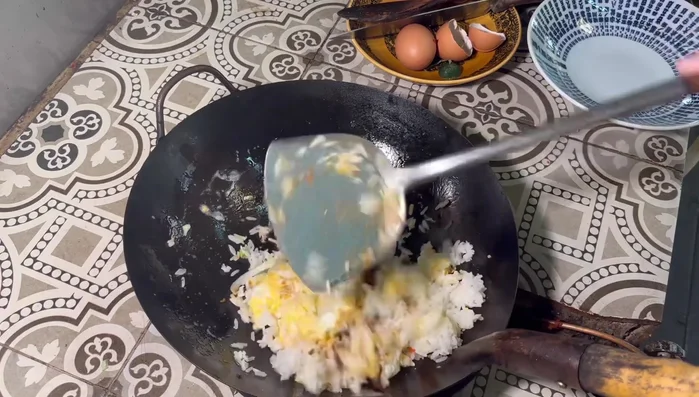 Add cooked rice and use a spatula to crush the rice grains until they break apart. Stir-fry until well combined.