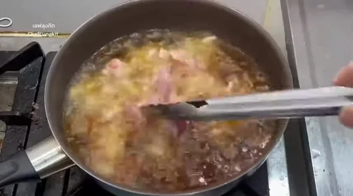 Remove the crispy pork from the pan and drain on a paper towel to remove excess oil.