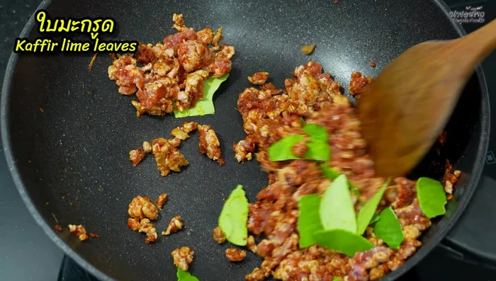 Add torn kaffir lime leaves to the pan and stir-fry for a short while to remove any fishy smell.