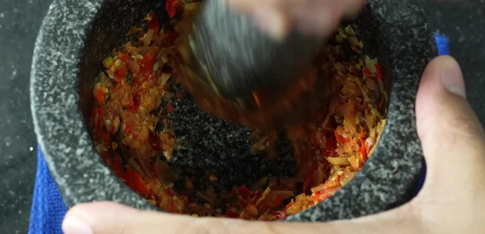 Add shrimp paste and pound again to mix well. This creates the curry paste.